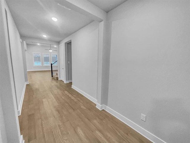 hallway featuring stairs, wood finished floors, and baseboards