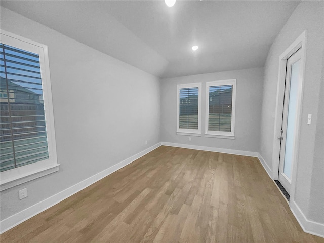 unfurnished room featuring baseboards, a healthy amount of sunlight, and wood finished floors