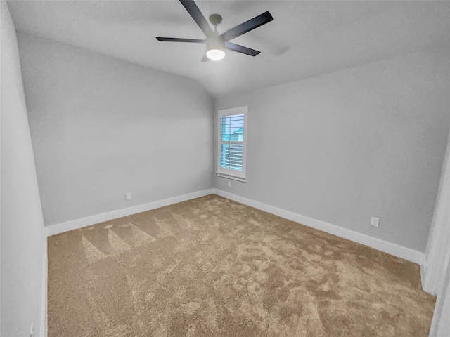 empty room featuring baseboards, lofted ceiling, ceiling fan, and carpet flooring