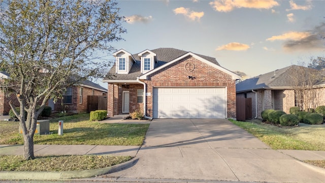 view of front facade with driveway, fence, an attached garage, a front yard, and brick siding