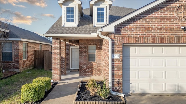 4011 Ridgetop Dr, Heartland, TX 75126 - doorway to property featuring fence, brick siding, an attached garage, and a shingled roof