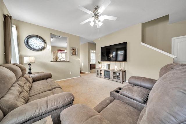 carpeted living area featuring baseboards and ceiling fan