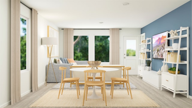 dining space featuring plenty of natural light, baseboards, and light wood finished floors