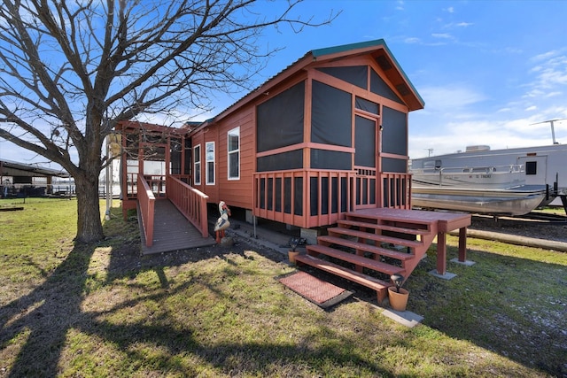 back of house featuring a yard and a sunroom