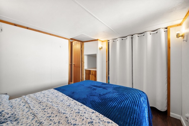 bedroom with dark wood-type flooring