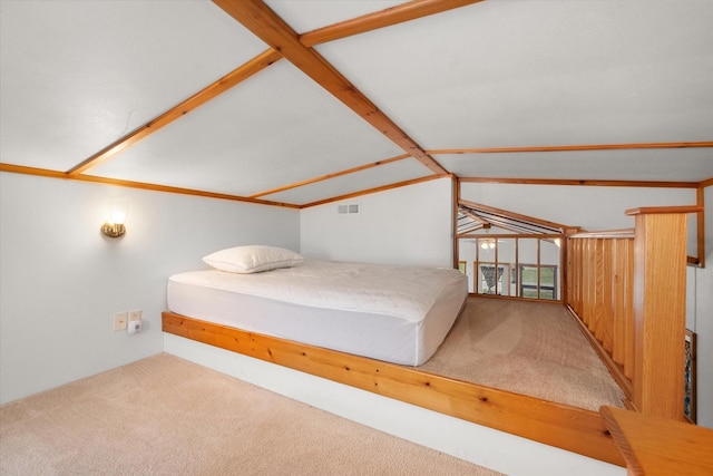 unfurnished bedroom featuring visible vents, carpet, and vaulted ceiling with beams