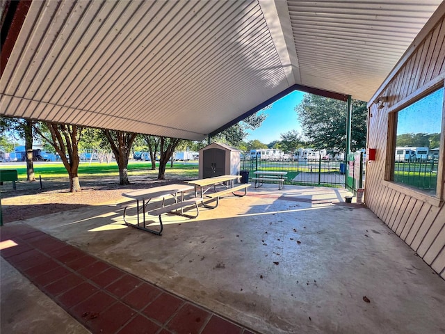 view of home's community featuring an outbuilding, fence, a shed, and a patio area