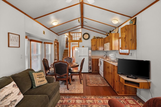 living room with dark wood-style flooring, stairs, and vaulted ceiling