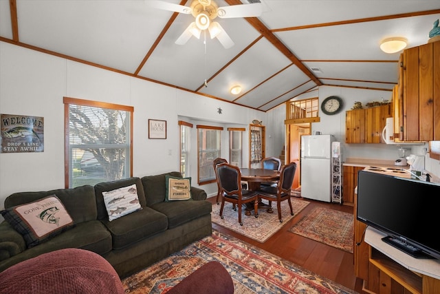 living room with a ceiling fan, vaulted ceiling, wood finished floors, and visible vents