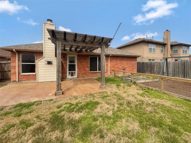 rear view of house with brick siding, a pergola, a fenced backyard, and a patio area