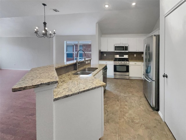 kitchen featuring visible vents, a sink, appliances with stainless steel finishes, white cabinetry, and backsplash