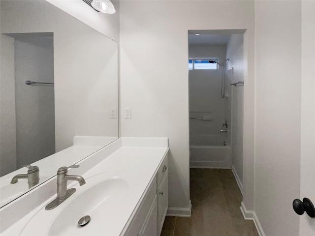 bathroom with vanity,  shower combination, and baseboards