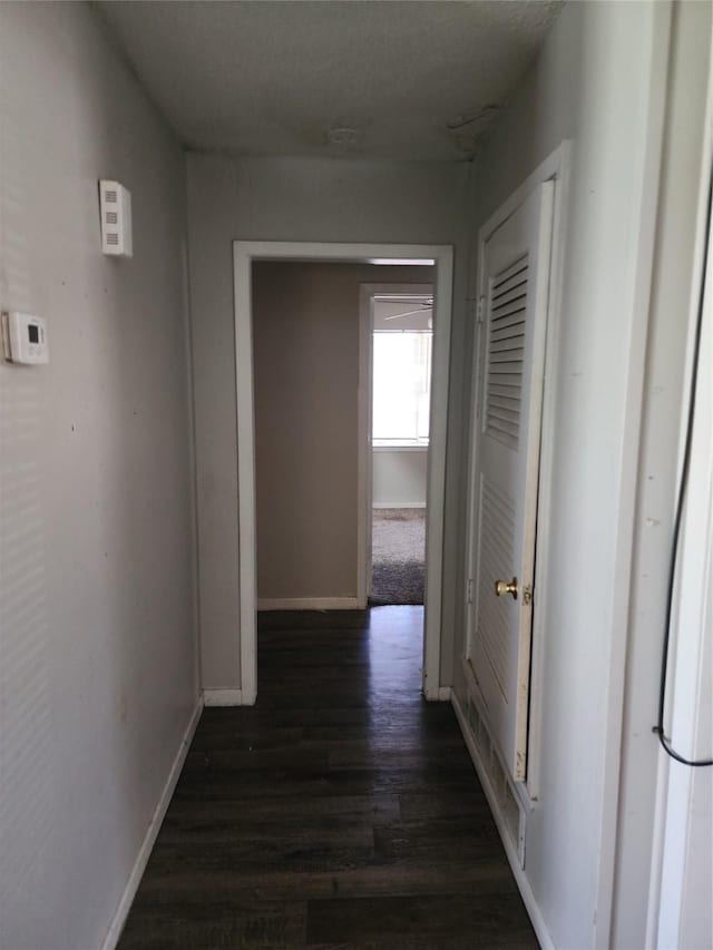 hallway with dark wood-style floors and baseboards