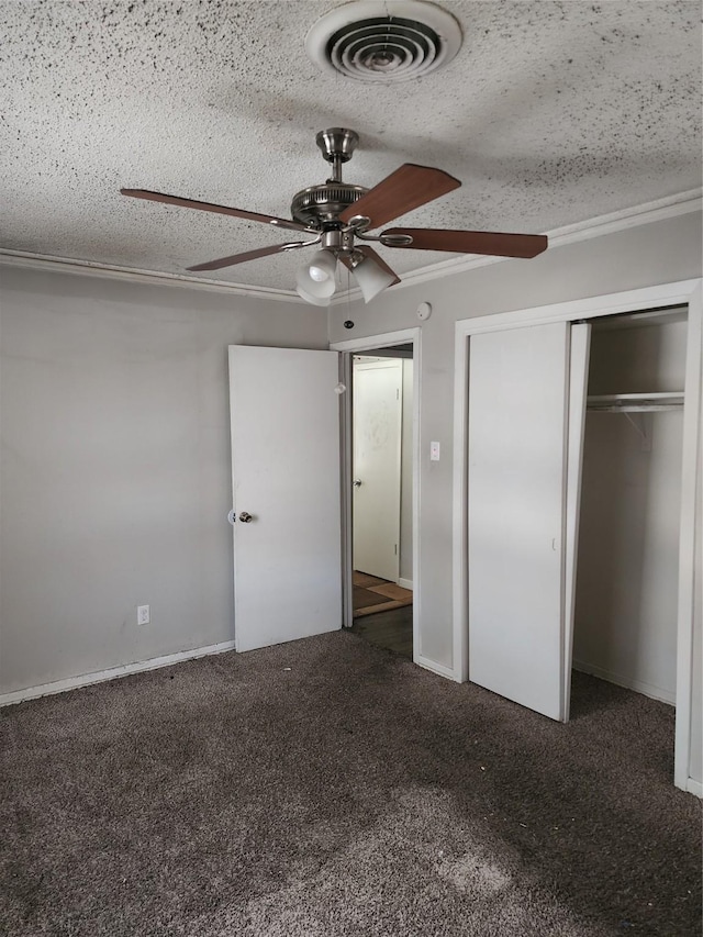 unfurnished bedroom with visible vents, carpet, a closet, and a textured ceiling