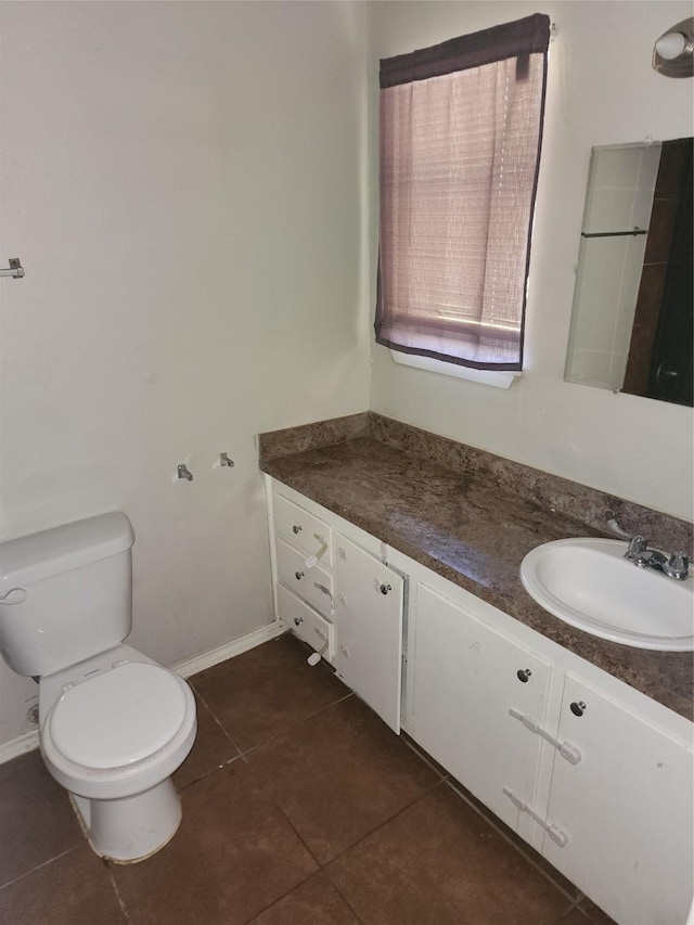 bathroom featuring baseboards, toilet, vanity, and tile patterned flooring