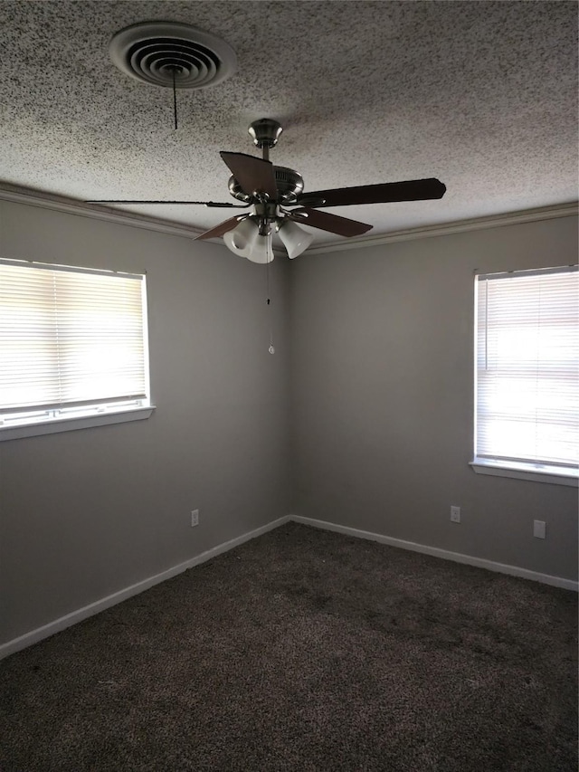 empty room with a healthy amount of sunlight, visible vents, carpet floors, and a textured ceiling