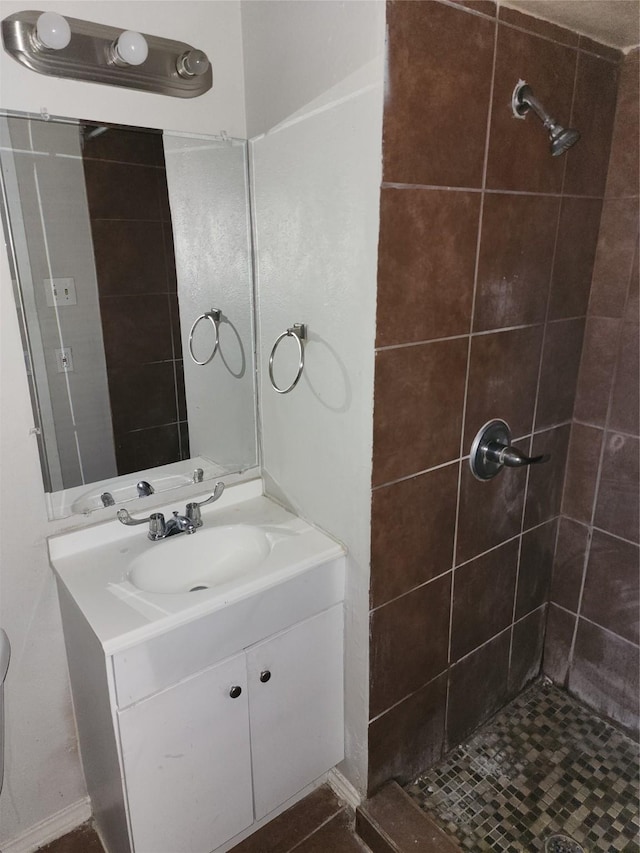 full bathroom featuring vanity and a tile shower