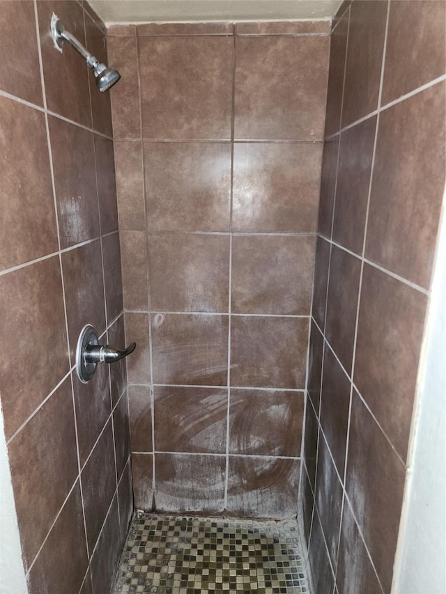 interior details with a tile shower