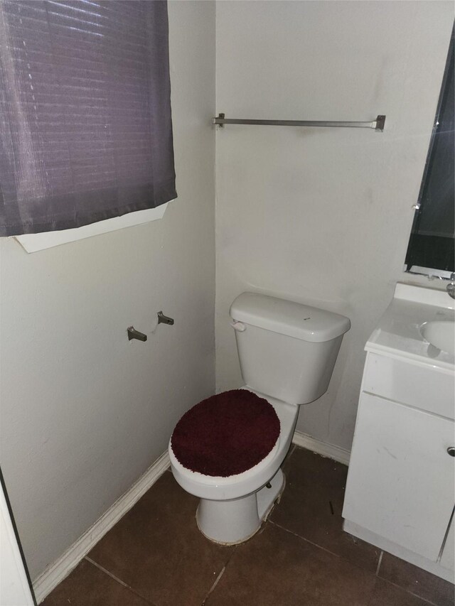 bathroom with baseboards, toilet, vanity, and tile patterned flooring