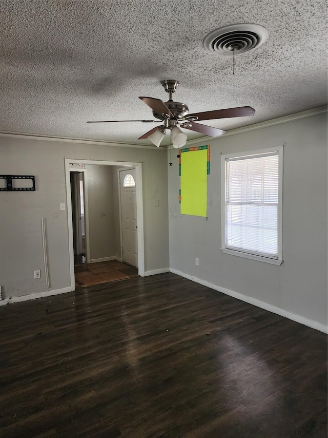 spare room with visible vents, a textured ceiling, baseboards, and wood finished floors