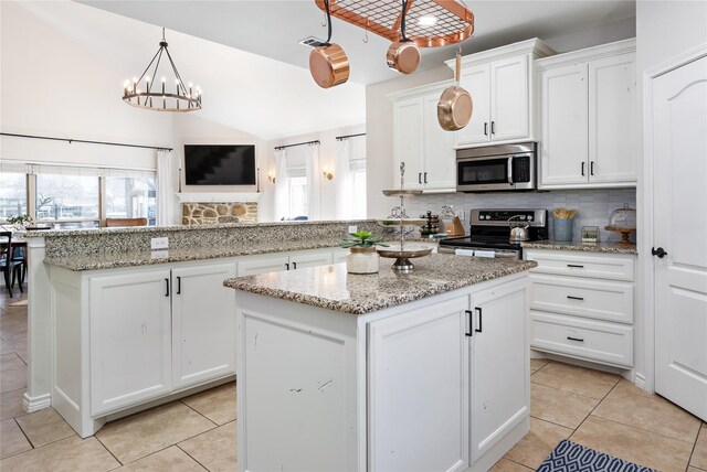 156 Palisade Dr, Gun Barrel City, TX 75156 - kitchen featuring decorative backsplash, a kitchen island, appliances with stainless steel finishes, and white cabinets