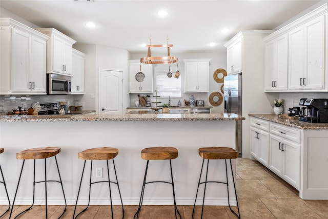 156 Palisade Dr, Gun Barrel City, TX 75156 - kitchen with white cabinets, appliances with stainless steel finishes, and a breakfast bar