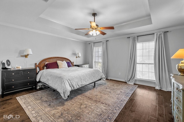 bedroom with crown molding, baseboards, ceiling fan, dark wood-style floors, and a raised ceiling