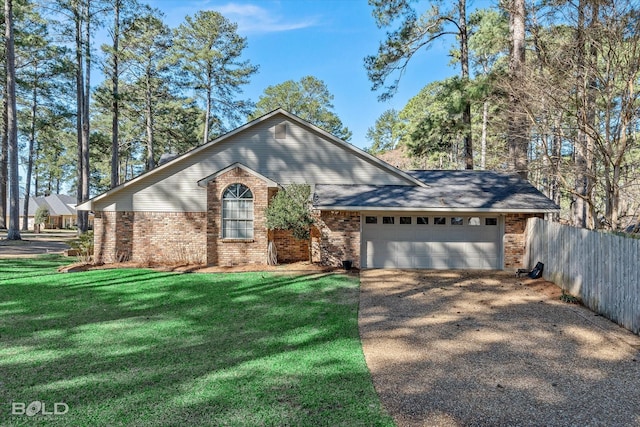 view of front of home with brick siding, a front lawn, fence, a garage, and driveway