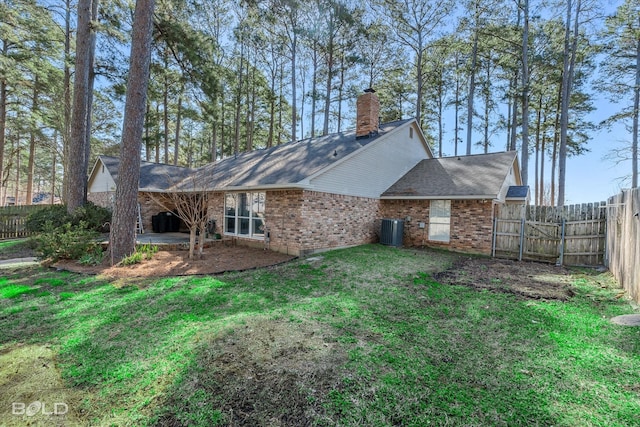 rear view of property with brick siding, fence, central AC, a lawn, and a patio