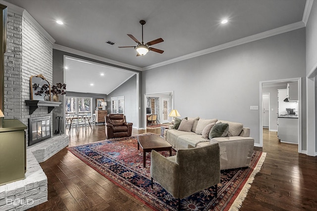 living area featuring visible vents, crown molding, baseboards, dark wood finished floors, and a fireplace