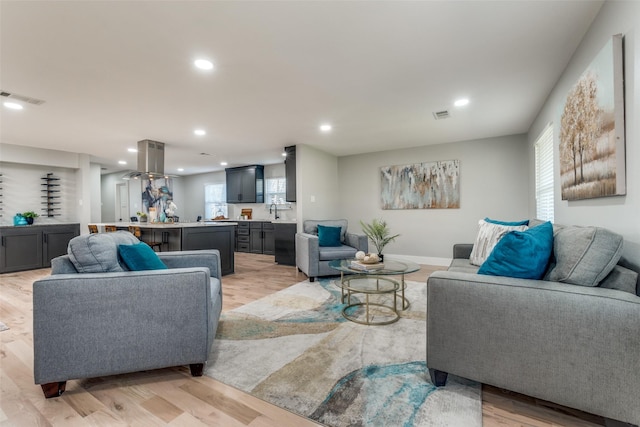 living area featuring recessed lighting, visible vents, light wood-style flooring, and baseboards