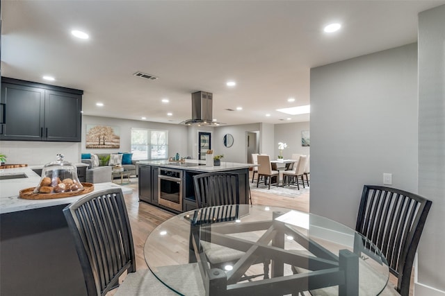 dining room with a ceiling fan, recessed lighting, visible vents, and light wood finished floors