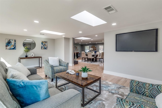 living room with light wood finished floors, visible vents, recessed lighting, and baseboards