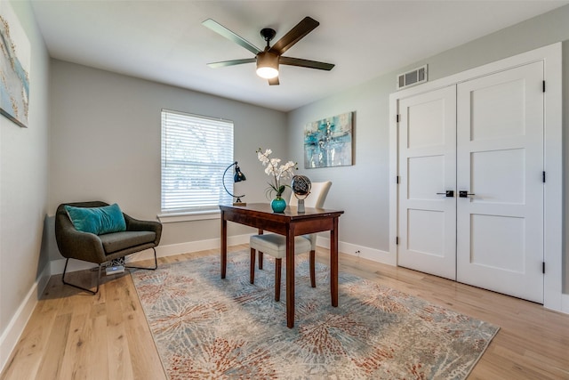 home office with light wood-type flooring, visible vents, baseboards, and a ceiling fan