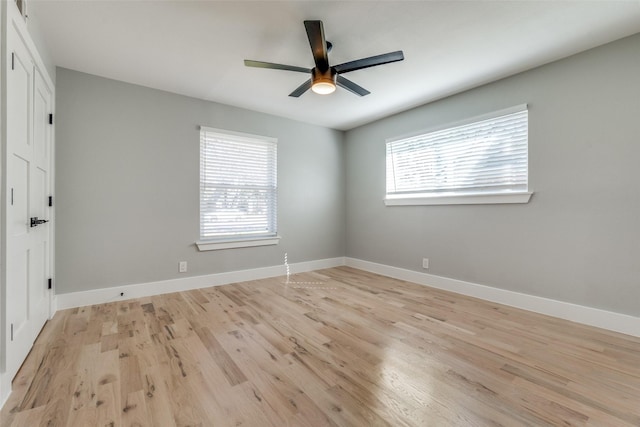 unfurnished room featuring light wood finished floors, baseboards, and a wealth of natural light