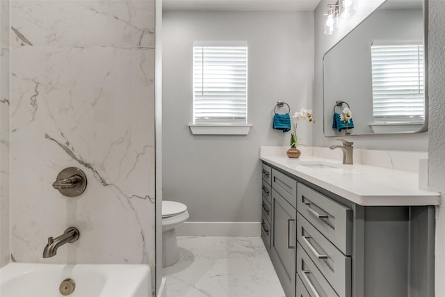 full bathroom featuring toilet, marble finish floor, washtub / shower combination, baseboards, and vanity