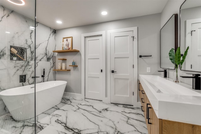 bathroom featuring vanity, stone wall, recessed lighting, a freestanding bath, and marble finish floor