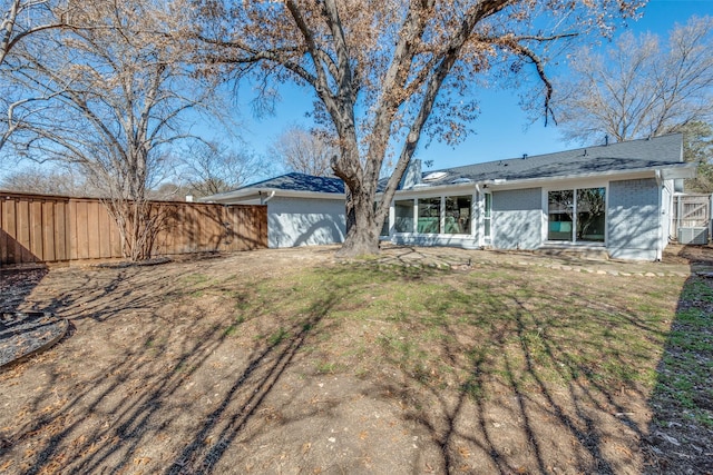 exterior space with a front yard, an attached garage, fence, and brick siding