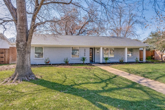 single story home featuring brick siding, a shingled roof, a front lawn, and fence