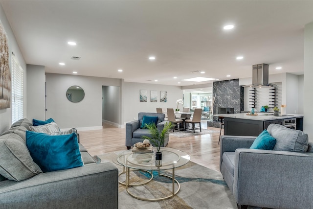 living room with visible vents, recessed lighting, baseboards, and light wood-style floors