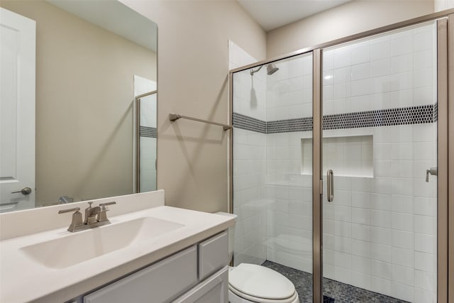 full bath with vanity, toilet, and a stall shower