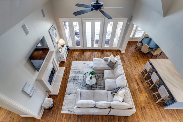 living area with wood finished floors, baseboards, and ceiling fan