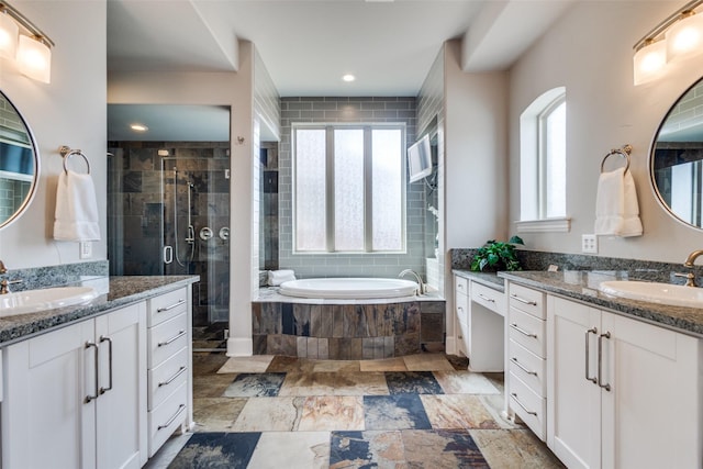 bathroom with two vanities, a shower stall, a bath, and a sink