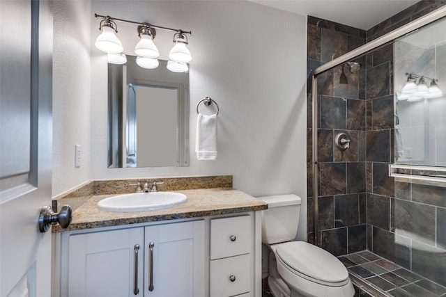 full bathroom with a shower stall, vanity, and toilet