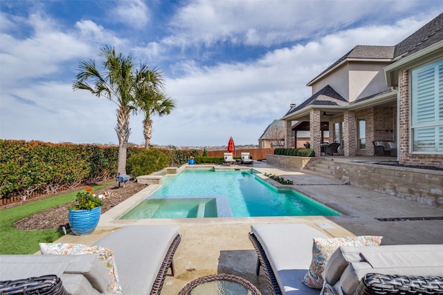 view of pool featuring a pool with connected hot tub, a fenced backyard, and a patio area