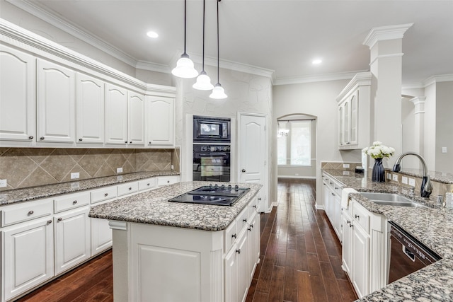 kitchen with light stone counters, a sink, black appliances, dark wood-type flooring, and backsplash