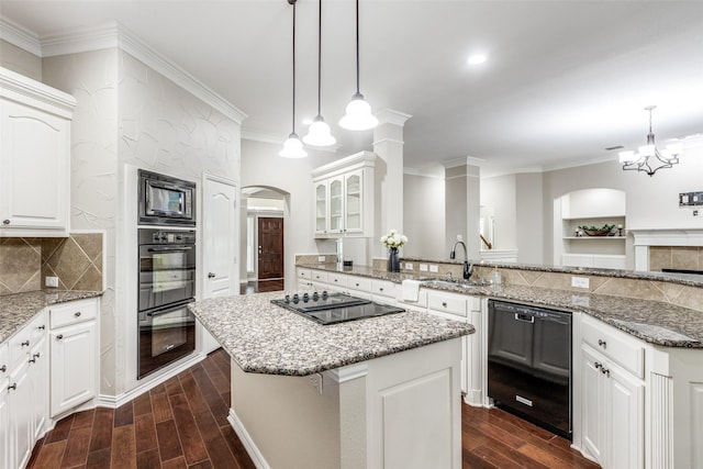 kitchen with wood finish floors, a kitchen island, ornamental molding, a sink, and black appliances