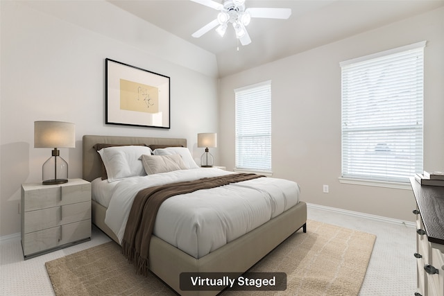 bedroom with vaulted ceiling, multiple windows, light colored carpet, and baseboards