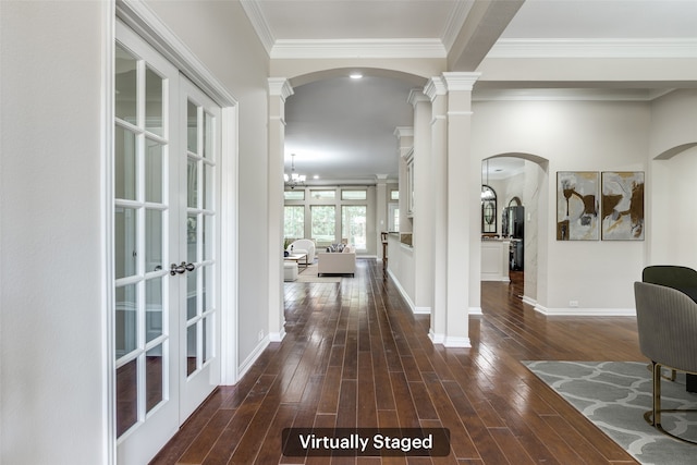 hall featuring dark wood finished floors, decorative columns, and baseboards