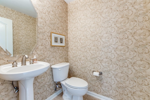 bathroom with tile patterned flooring, toilet, and baseboards